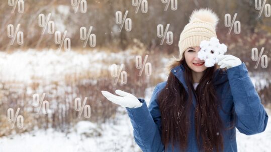 Winter sales and discount concepts. Woman on background of winter landscape and flying percent.